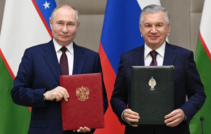 El presidente ruso Vladimir Putin, a la izquierda, y el presidente uzbeko Shavkat Mirziyoyev asisten a una ceremonia de firma tras una reunión en formato ampliado en el Palacio Presidencial de Kuksaroy en Tashkent, Uzbekistán, el lunes 27 de mayo de 2024. (Sergei Bobylev, Sputnik, Kremlin Pool Photo via AP)