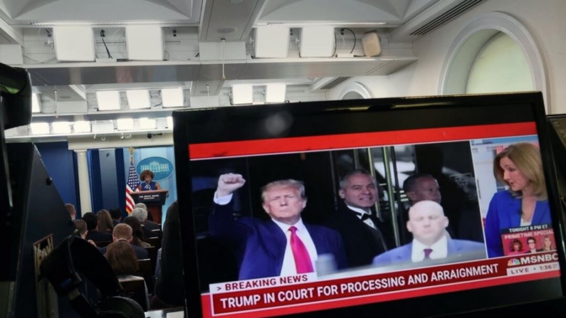 Una pantalla de televisión muestra una imagen del expresidente Donald Trump mientras es procesado y la secretaria de prensa de la Casa Blanca, Karine Jean-Pierre, ofreciendo una rueda de prensa, en la Casa Blanca en Washington el 4 de abril de 2023. (Kevin Dietsch/Getty Images)