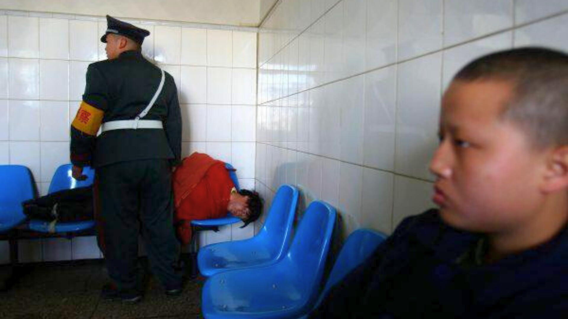 Un hombre que acaba de ser escoltado al Hospital Mental de Kunming yace en sillas en Kunming, provincia de Yunnan, suroeste de China
