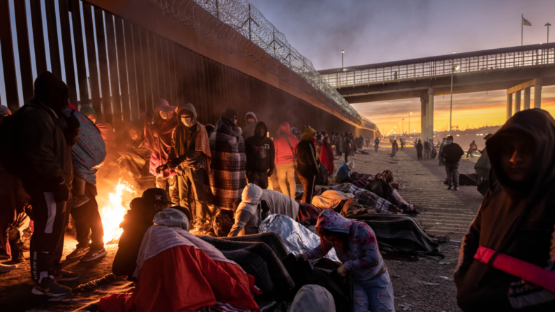 Foto de archivo de inmigrantes junto a la cerca fronteriza entre Estados Unidos y México el 22 de diciembre de 2022 en El Paso, Texas. (John Moore/Getty Images)