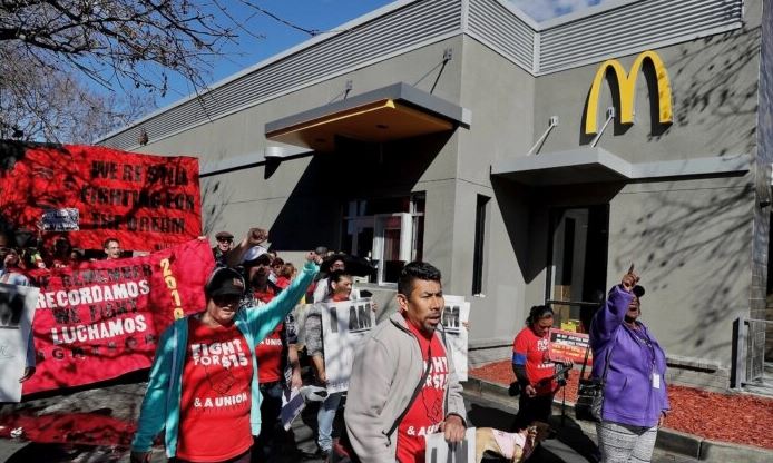 Trabajadores de comida rápida y miembros del sindicato llevan carteles mientras realizan una protesta frente a un restaurante McDonald's en Oakland, California, el 12 de febrero de 2018. (Justin Sullivan/Getty Images)