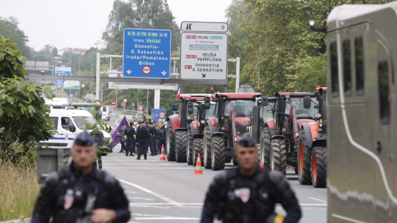 La policía francesa vigila el paso fronterizo entre España y Francia, en Irún, donde agricultores españoles llegados desde diversos puntos del país bloquean la zona a pie y con tractores. EFE/Juan Herrero