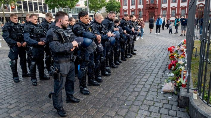 Oficiales de policía alemanes conmemoran a un colega en Mannheim, Alemania, tras enterarse de que un oficial de policía que fue apuñalado hace dos días murió el domingo, el 2 de junio de 2024. (Michael Probst/AP Photo)