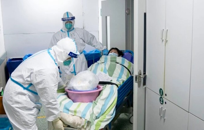 Trabajadores médicos trasladan a un paciente fuera de la unidad de cuidados intensivos del Hospital Zhongnan de la Universidad de Wuhan en Wuhan, en la provincia de Hubei, en el centro de China. El 24 de enero de 2020. (Zong Qi/Xinhua vía AP)