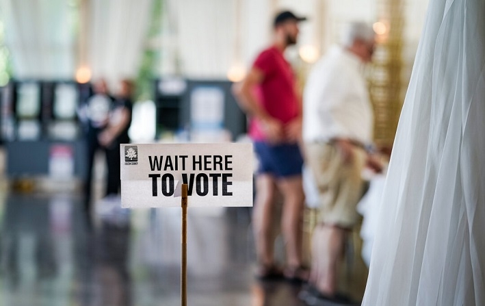 Cartel de "Espere aquí para votar" en un colegio electoral mientras los votantes se registran para votar en Atlanta, Georgia, el 21 de mayo de 2024. (Elijah Nouvelage/Getty Images)
