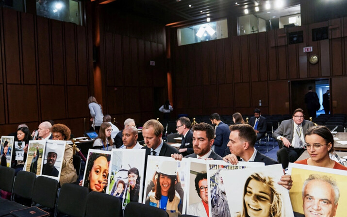 Familiares esperan un testimonio del CEO de Boeing, Dennis Muilenburg, mientras sostienen fotografías de las víctimas de dos accidentes del Boeing 737 MAX en los que fallecieron 346 personas, en Capitol Hill, el 29 de octubre de 2019. (Sarah Silbiger/Reuters)
