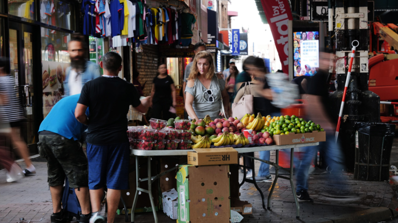 Un vendedor ambulante vende frutas a lo largo de Roosevelt Avenue en Queens, un área con un alto número de inmigrantes recientes, el 16 de agosto de 2023 en la ciudad de Nueva York. (Spencer Platt/Getty Images)