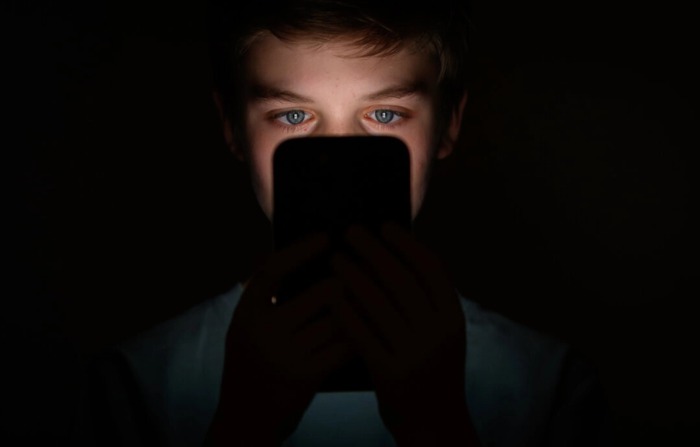 En esta ilustración fotográfica, un adolescente mira la pantalla de un teléfono móvil en Londres, el 17 de enero de 2023. (Leon Neal/Getty Images)