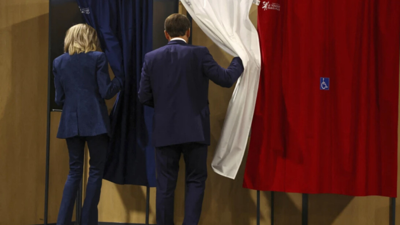 El presidente francés Emmanuel Macron y su esposa Brigitte Macron entran en una cabina de votación durante las elecciones europeas, en Le Touquet-Paris-Plage, al norte de Francia, el domingo 9 de junio de 2024. (Hannah McKay/Pool vía AP)