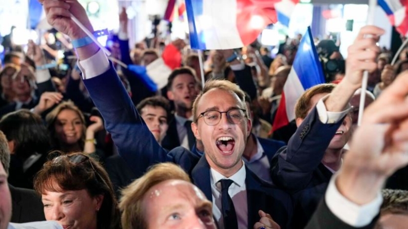 Simpatizantes del partido Agrupación Nacional francés reaccionan en la sede del partido la noche de las elecciones en París, el 9 de junio de 2024. (AP Photo/Lewis Joly)