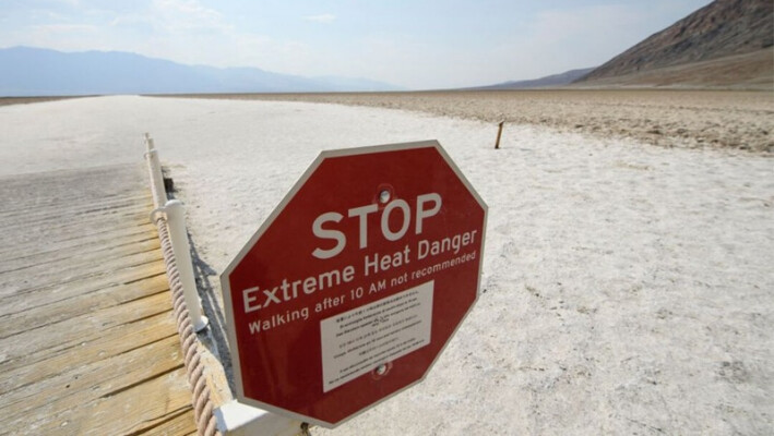 Una señal advierte sobre el peligro de calor extremo en las salinas de Badwater Basin en el Parque Nacional del Valle de la Muerte el 17 de junio de 2021, en el condado de Inyo, California. (Patrick T. Fallon/AFP vía Getty Images/TNS)