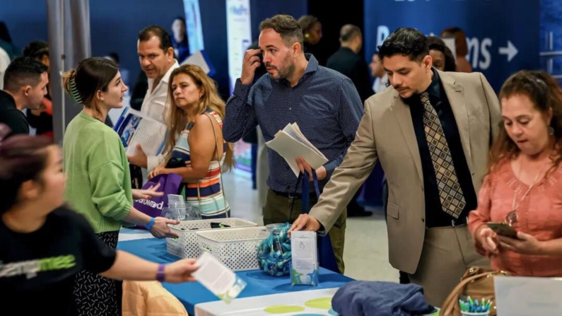 Los solicitantes de empleo conversan con los reclutadores en una feria de empleo en Sunrise, Florida, el 23 de febrero de 2023. (Joe Raedle/Getty Images)