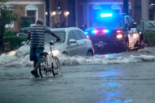 Un ciclista atraviesa calles inundadas en Stirling Road cerca de Federal Highway en Hollywood, Florida, el 12 de junio de 2024. (Mike Stocker/South Florida Sun-Sentinel vía AP)