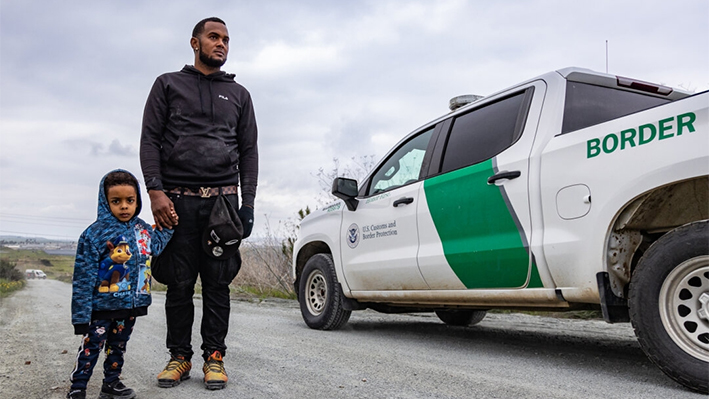 Agentes de la Patrulla Fronteriza pasan junto a inmigrantes ilegales en Otay Mesa, California, el 29 de febrero de 2024. (John Fredricks/The Epoch Times)