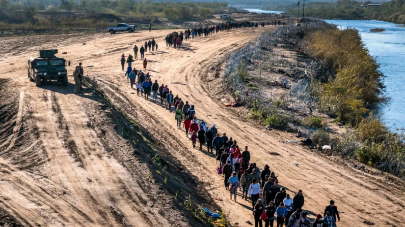 Un grupo de más de 1000 inmigrantes camina hacia un centro de procesamiento de campo de la Patrulla Fronteriza de EE.UU. después de cruzar el Río Grande desde México el 18 de diciembre de 2023 en Eagle Pass, Texas. (Foto de John Moore/Getty Images)
