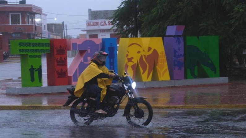 Un hombre protegido con capa maneja su moto en medio de un fuerte aguacero en la población de Tizimin en el estado de Yucatán (México). Imagen de archivo. EFE/ Cuauhtemoc Moreno