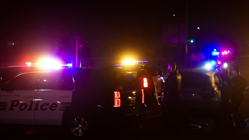 Oficiales de policía se encuentran en la intersección de la autopista US 101 y la salida Moorpark Road mientras los vehículos policiales cierran el área en respuesta a un tiroteo en un bar en Thousand Oaks, California. (FREDERIC J. BROWN/AFP via Getty Images)