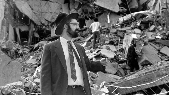 Un hombre camina sobre los escombros que quedaron tras la explosión de una bomba en la Asociación Mutual Israelí Argentina (AMIA) en Buenos Aires, el 18 de julio de 1994. (ALI BURAFI/AFP vía Getty Images)