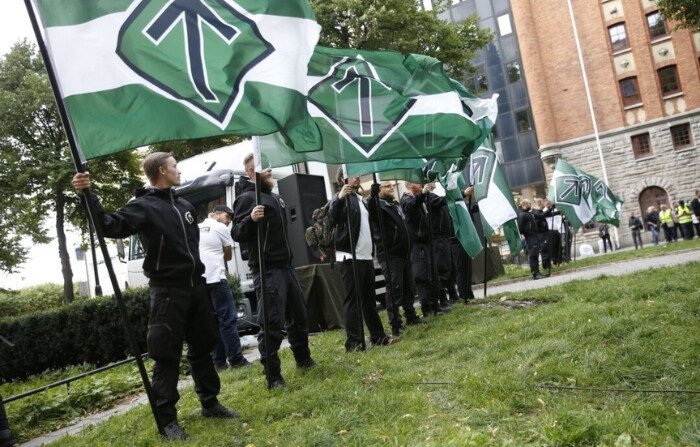 Simpatizantes del neonazi Movimiento de Resistencia Nórdica sostienen banderas durante una manifestación en la plaza Kungsholmstorg en Estocolmo, Suecia, el 25 de agosto de 2018. (Fredrik Persson / Agencia de noticias TT / AFP vía Getty Images)