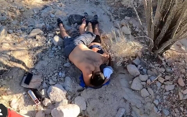 Dos excursionistas tendidos en el suelo antes de la llegada de una unidad de rescate del Sheriff del Condado de Riverside al Sendero Ladder Canyon, en Mecca, California, el 9 de junio de 2024. (Oficina del Sheriff del Condado de Riverside vía AP)