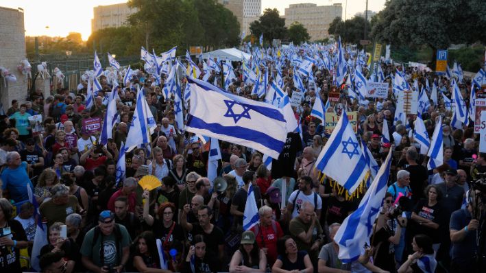 Varias personas participan en una protesta contra el gobierno del primer ministro israelí Benjamin Netanyahu, exigiendo nuevas elecciones y la liberación de los rehenes secuestrados en la Franja de Gaza por el grupo terrorista Hamás, frente al Knéset, el parlamento de Israel, en Jerusalén, el lunes 17 de junio de 2024. (AP Photo/Ohad Zwigenberg)