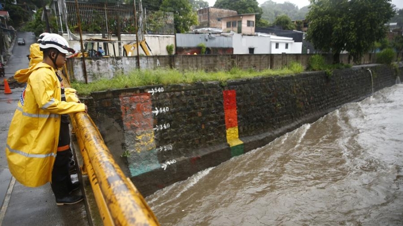 Un miembro de protección civil inspecciona el caudal de un río el 16 de junio de 2024, en San Salvador (El Salvador). EFE/Rodrigo Sura
