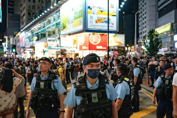 Agentes de policía patrullan el distrito de Causeway Bay de Hong Kong, cerca del Parque Victoria, donde tradicionalmente se reunía anualmente la gente para llorar a las víctimas de la represión china de la plaza de Tiananmen en 1989, el 4 de junio de 2024. Desde que entró en vigor la nueva ley de seguridad nacional, el acto ya no se celebra. (Anthony Kwan/Getty Images)