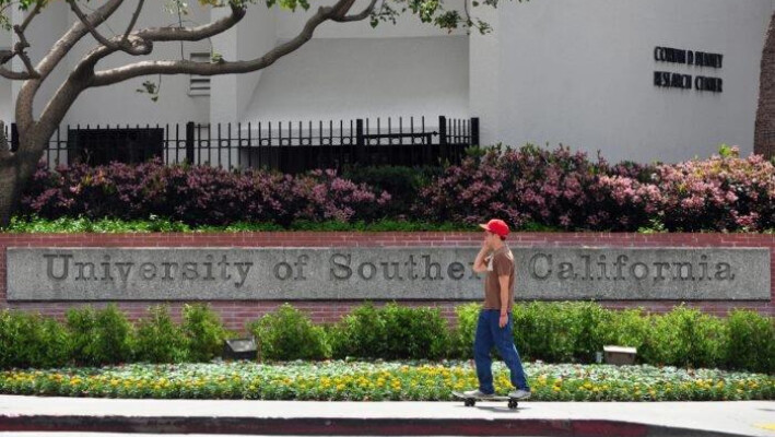 Un estudiante pasa su patineta por la entrada del campus de la Universidad del Sur de California en Los Ángeles el 11 de abril de 2012. (Frederic J. Brown/AFP vía Getty Images)
