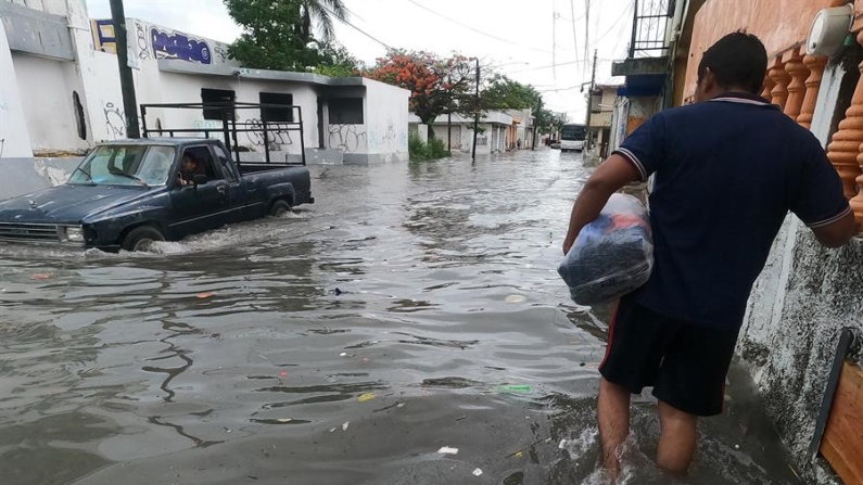 Un hombre y vehículo circulan por una calle inundada debido a las fuertes lluvias, el 18 de junio de 2024  en Cancún, estado de Quintana Roo (México). EFE/ Alonso Cupul
