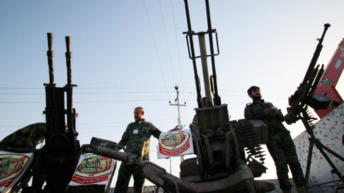 Combatientes del grupo chií Harakat Ansar Allah al-Awfiya desfilan con sus armas en la ciudad de Basora, en el sur de Irak, el 16 de junio de 2015. (Haidar Mohammed Ali/AFP vía Getty Images)