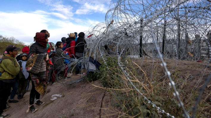 Migrantes esperan para entrar y pedir asilo en El Paso, Texas, desde Ciudad Juárez, Chihuahua, en México, el 2 de abril de 2024. (Christian Monterrosa/AFP vía Getty Images)