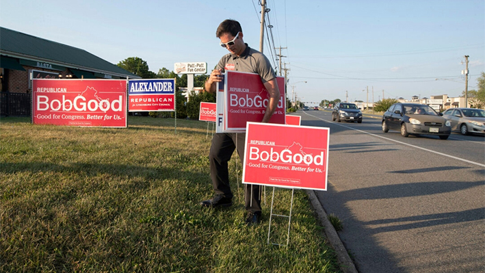 El simpatizante Phil Hamilton coloca carteles de campaña para el representante Bob Good, candidato en las primarias republicanas para el 5º Distrito del Congreso de Virginia, a lo largo de Timberlake Road en Lynchburg, Virginia, el 18 de junio de 2024. (AP Photo/P. Kevin Morley)