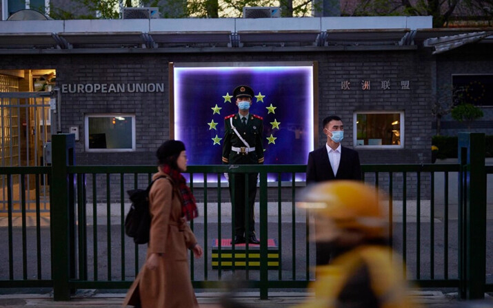 Miembros de la Policía Armada del Pueblo montan guardia frente a la bandera de la Unión Europea en la Delegación Europea antes de una rueda de prensa de la Presidenta de la Comisión Europea, Ursula von der Leyen, en Beijing, China, el 6 de abril de 2023.(Kevin Frayer/Getty Images)