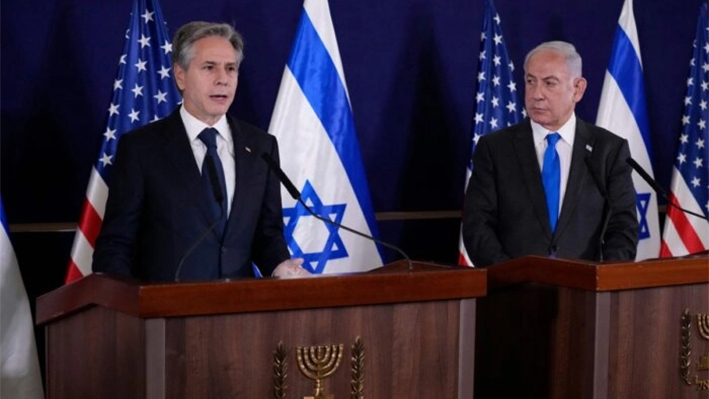 El primer ministro israelí, Benjamin Netanyahu (D), mira mientras el secretario de Estado estadounidense, Antony Blinken, hace declaraciones a los medios de comunicación en el interior de La Kirya, que alberga el Ministerio de Defensa israelí, tras su reunión en Tel Aviv el 12 de octubre de 2023. (Jacquelyn Martin/Pool/ AFP vía Getty Images)