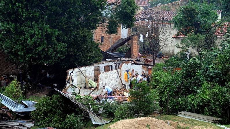 Varias personas observan la destrucción causada por un tornado en Capiata, Paraguay, en una fotografía de archivo. (Norberto Duarte/AFP vía Getty Images)