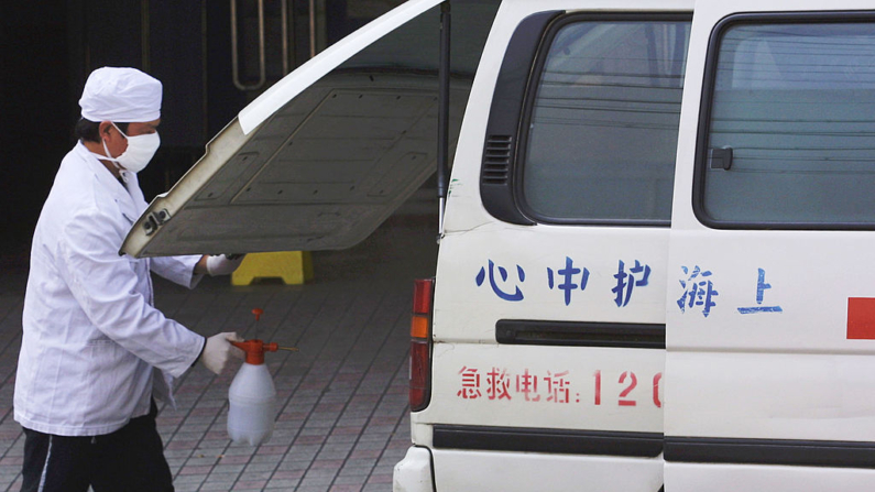 Un médico que usa una máscara quirúrgica desinfecta una ambulancia en un hospital en Shanghai, China. Imagen de archivo. (Kevin Lee/Getty Images)