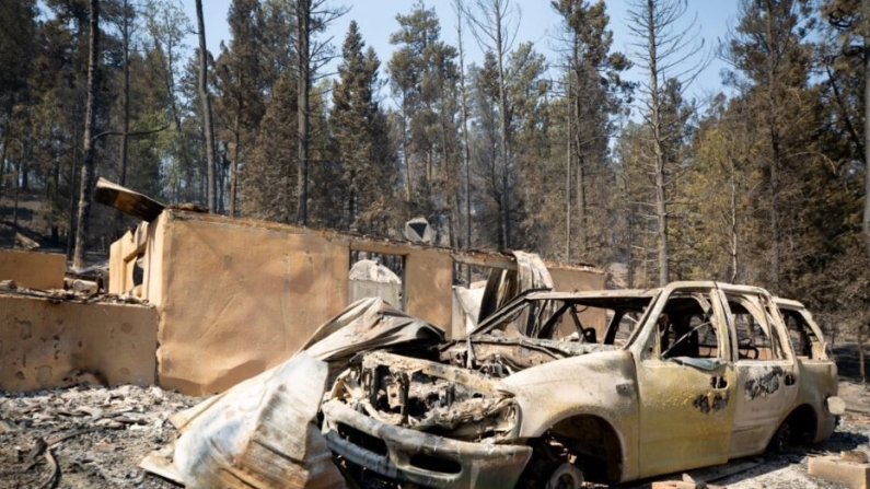 Un coche quemado frente a un edificio en ruinas tras el incendio South Fork Fire quemó la mayoría de las estructuras en Cedar Creek después de evacuaciones masivas de la ciudad Ruidoso, uevo México., el 18 de junio de 2024. (Kaylee Greenlee Beal/Reuters)