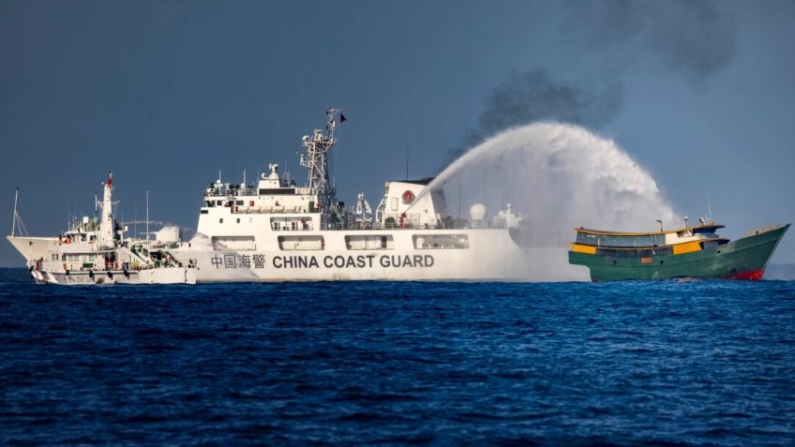 Un buque de la Guardia Costera china dispara un cañón de agua contra el Unaizah May 4, un buque fletado por la Armada filipina, que realiza una misión rutinaria de reabastecimiento a las tropas estacionadas en Second Thomas Shoal, en el mar de China Meridional, el 5 de marzo de 2024. (Ezra Acayan/Getty Images)