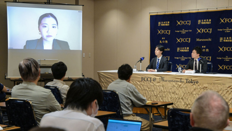 La activista de Hong Kong Anna Kwok (i) habla por vídeo desde Estados Unidos, mientras los activistas Alric Lee (c), residente en Japón, y Finn Lau (d), residente en el Reino Unido, escuchan durante una rueda de prensa en el Club de Corresponsales Extranjeros de Japón (FCCJ) en Tokio el 20 de junio de 2024. (Richard A. Brooks/AFP vía Getty Images)