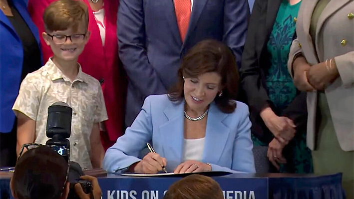 La gobernadora de Nueva York, Kathy Hochul, firma un proyecto de ley en Nueva York el 20 de junio de 2024. Hochul firmó un proyecto de ley que permitiría a los padres impedir que sus hijos reciban las publicaciones de las redes sociales sugeridas por el algoritmo de una plataforma, una medida para limitar los contenidos que, según los críticos, crean adicción. (Oficina del Gobernador de Nueva York vía AP)