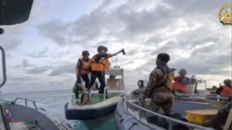 En esta foto proporcionada por las Fuerzas Armadas de Filipinas, guardacostas chinos sostienen cuchillos y machetes mientras se acercan a las tropas filipinas que están en una misión de reabastecimiento en el Segundo Thomas Shoal en el disputado Mar de China Meridional el 17 de junio de 2024. El jefe militar filipino lo comparó con un acto de piratería en el mar de la China Meridional. (Fuerzas Armadas de Filipinas vía AP)
