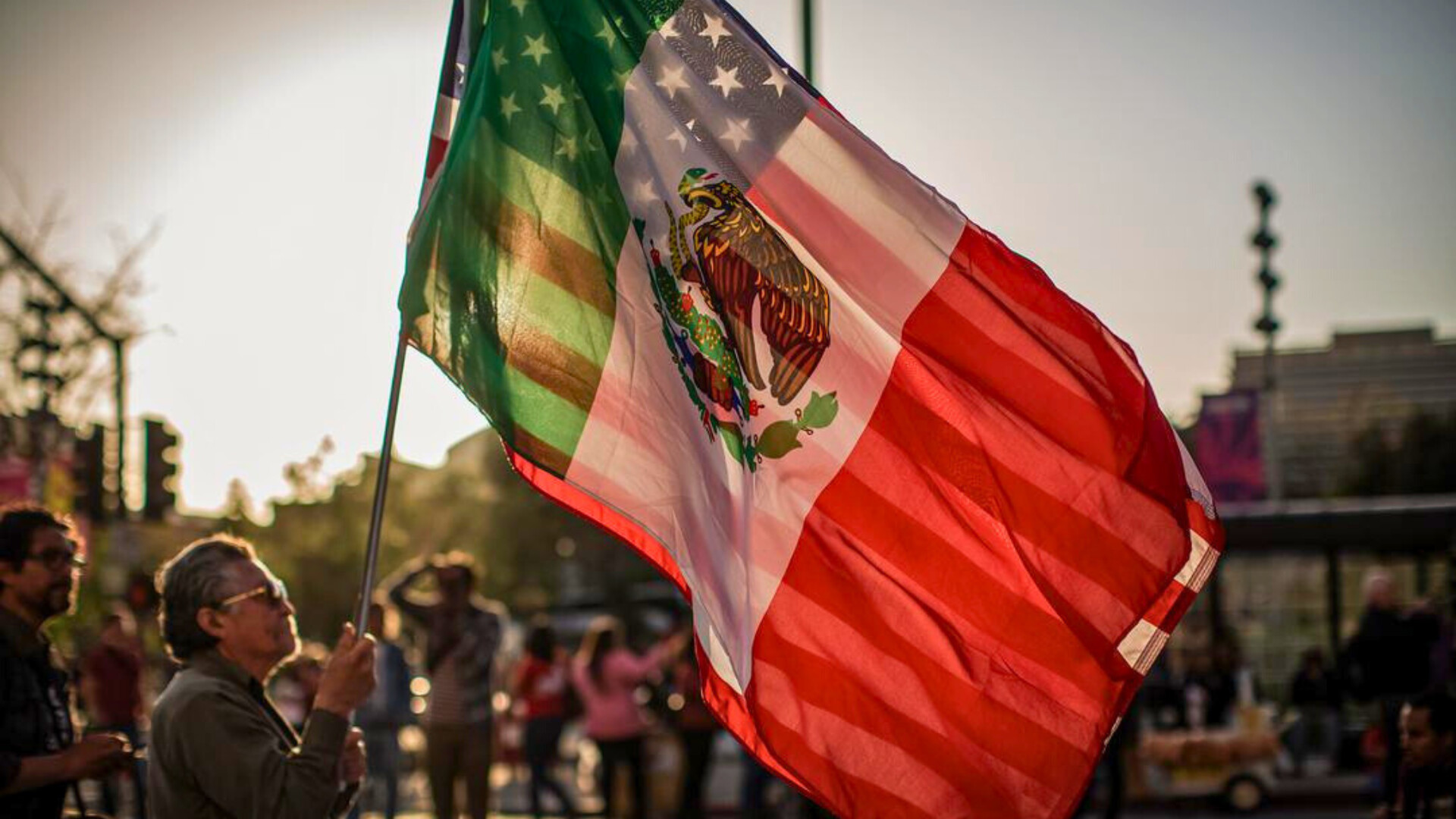 Un hombre porta una bandera estadounidense y una bandera mexicana en un mitin en Los Ángeles el 1 de mayo de 2019. Los latinos son ahora el grupo minoritario más grande de Estados Unidos. 