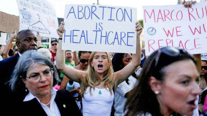 Una manifestante sostiene un cartel mientras se manifiesta en Miami tras la sentencia del Corte Suprema de Estados Unidos en el caso del aborto Dobbs contra Jackson Women's Health Organization, que anuló la histórica decisión sobre el aborto Roe vs. Wade, el 24 de junio de 2022. (Marco Bello/Reuters)