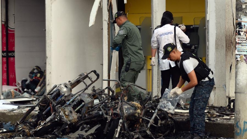 Fotografía del 12 de junio de 2024 en donde se ven investigadores de la Policía colombiana mientras recogen evidencias luego de una explosión en el municipio de Jamundí (Colombia). EFE/Ernesto Guzmán Jr.