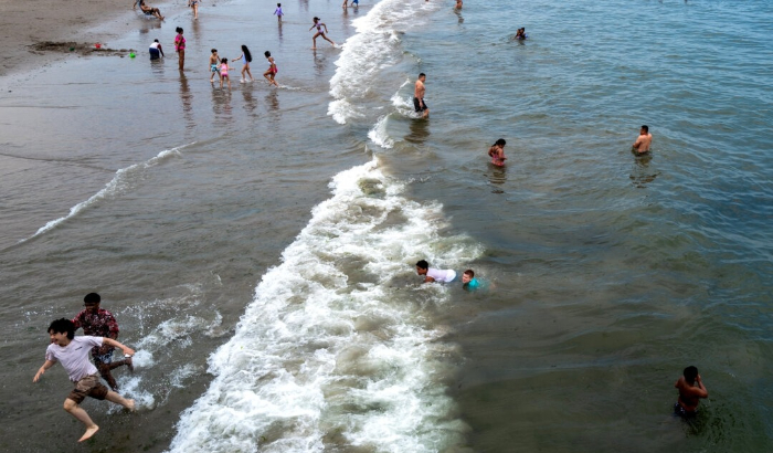 La gente visita la playa de Coney Island en una tarde sofocante del primer fin de semana del verano, en el distrito de Brooklyn de la ciudad de Nueva York el 22 de junio de 2024. (Spencer Platt/Getty Images)