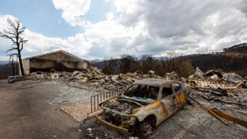 Un coche carbonizado y los restos del Swiss Chalet Hotel son fotografiados después de ser destruidos por el incendio South Fork Fire en Ruidoso, un pueblo de montaña de Nuevo México, el 22 de junio de 2024. (Andres Leighton/Foto AP)