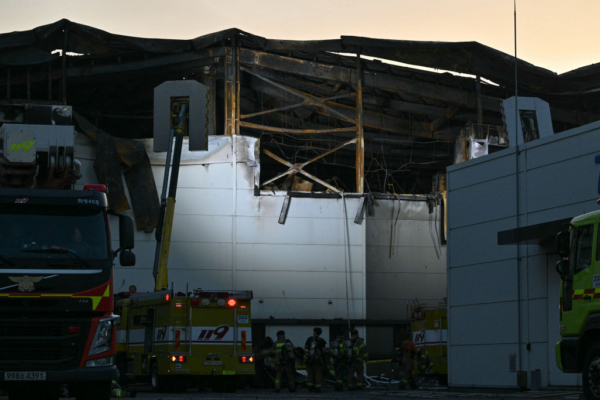 Los focos iluminan una sección de una fábrica de baterías de litio propiedad del fabricante surcoreano de baterías Aricell al anochecer, hora local, tras un incendio masivo en las instalaciones en Hwaseong el 24 de junio de 2024. (Anthony Wallace/AFP vía Getty Images)