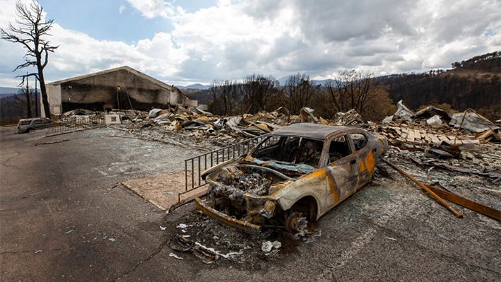 Un coche carbonizado y los restos del hotel Swiss Chalet tras ser destruidos por el incendio de South Fork en el pueblo de montaña de Ruidoso, N.M., el 22 de junio de 2024. (Andres Leighton/Foto AP)