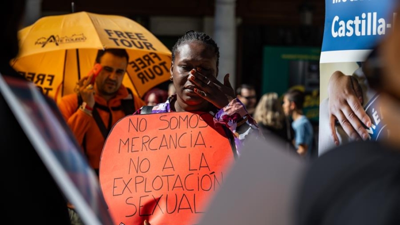 Una mujer con un cartel en el que se puede leer "No somos mercancía. No a la explotación sexual" durante una concentración en Toledo (España) por el Día Internacional contra la Explotación Sexual y el Tráfico de Mujeres, Niñas y Niños. EFE/Ángeles Visdómine
