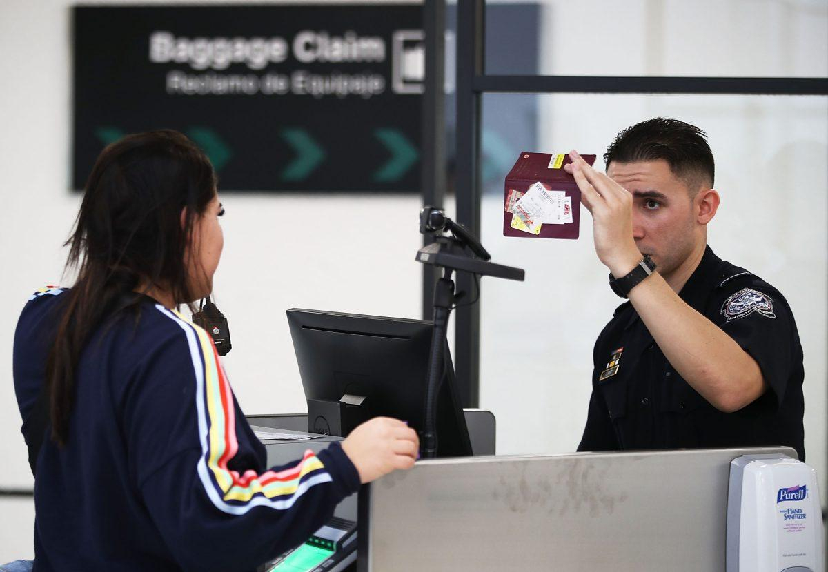 Un oficial de Aduanas y Protección Fronteriza de los Estados Unidos utiliza tecnología de reconocimiento facial para examinar a un viajero que ingresa a los Estados Unidos en el Aeropuerto Internacional de Miami, el 27 de febrero de 2018. (Joe Raedle/Getty Images)